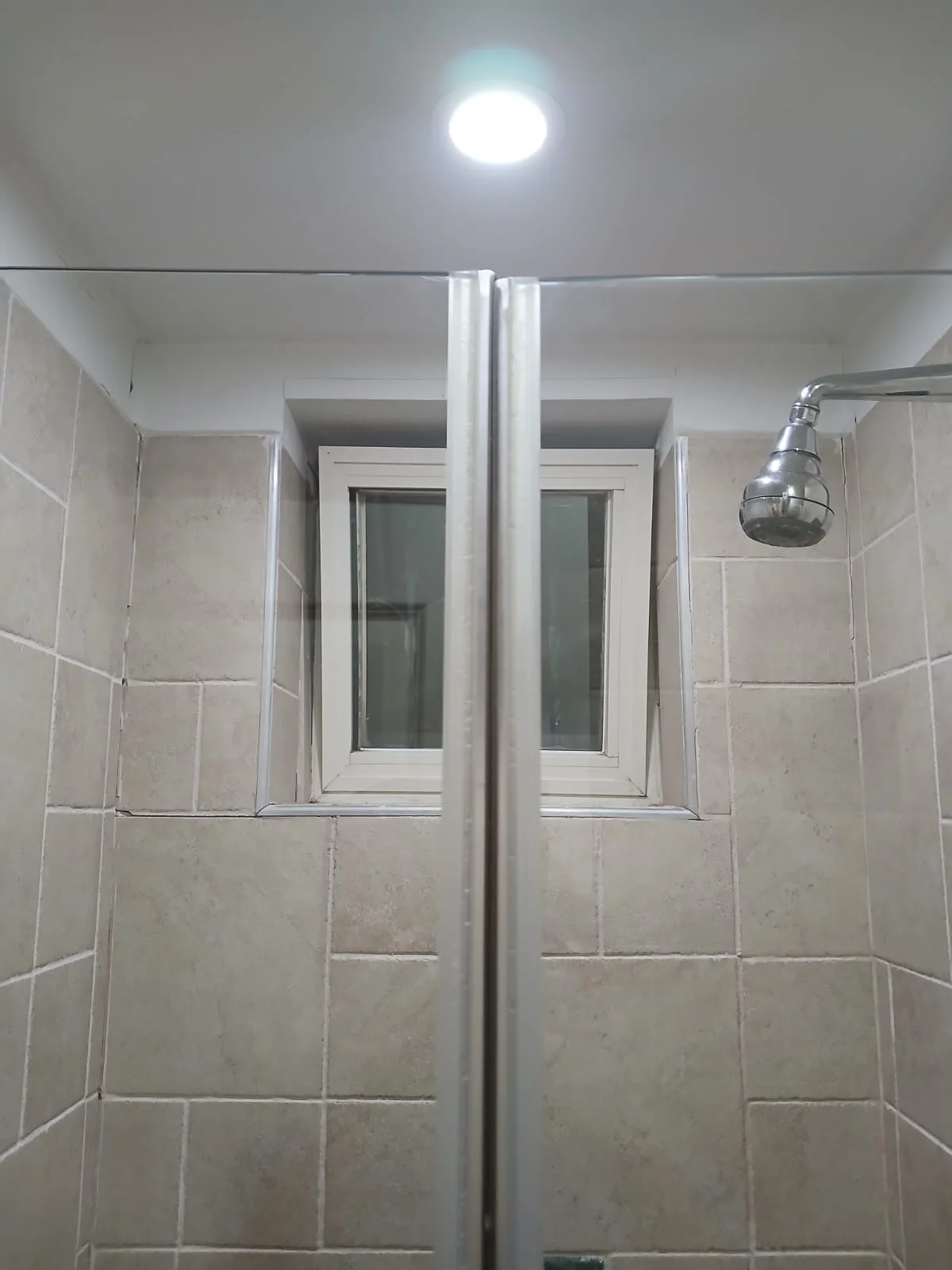 A cleaned shower enclosure and bathroom window